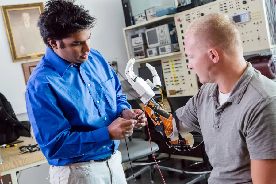  Dr. Akhtar (left) fits Retired Army Sgt. Garrett Anderson, who lost his hand and most of his forearm from an IED blast in Iraq, with a Psyonic prosthetic hand. 