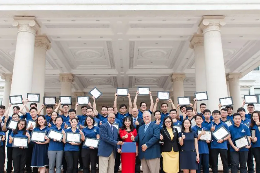 VinUniversity logo with picture of students raising certificates over head while standing on steps of a building with white pillars. 