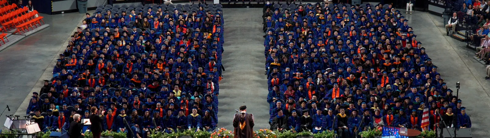 view of stage and attendees at doctoral hooding ceremony in State Farm Center