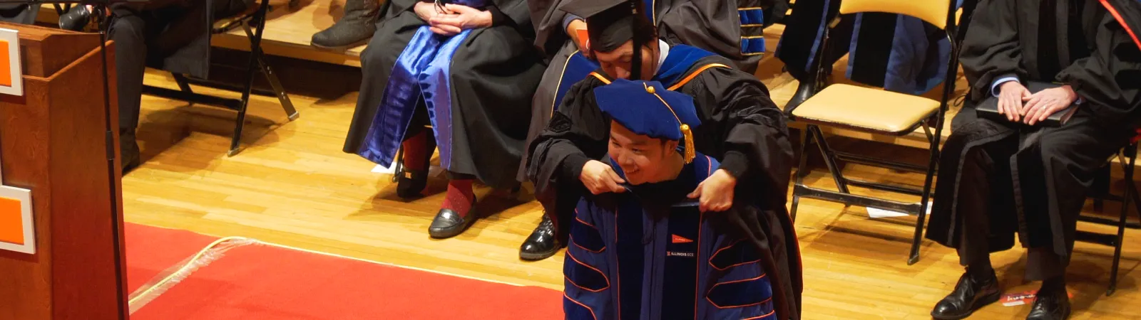 A graduate getting hooded by a mentor