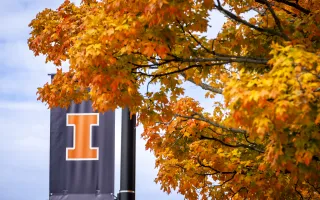 blue block-I street banner against bright orange fall foliage