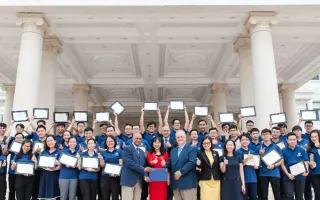 VinUniversity logo with picture of students raising certificates over head while standing on steps of a building with white pillars. 