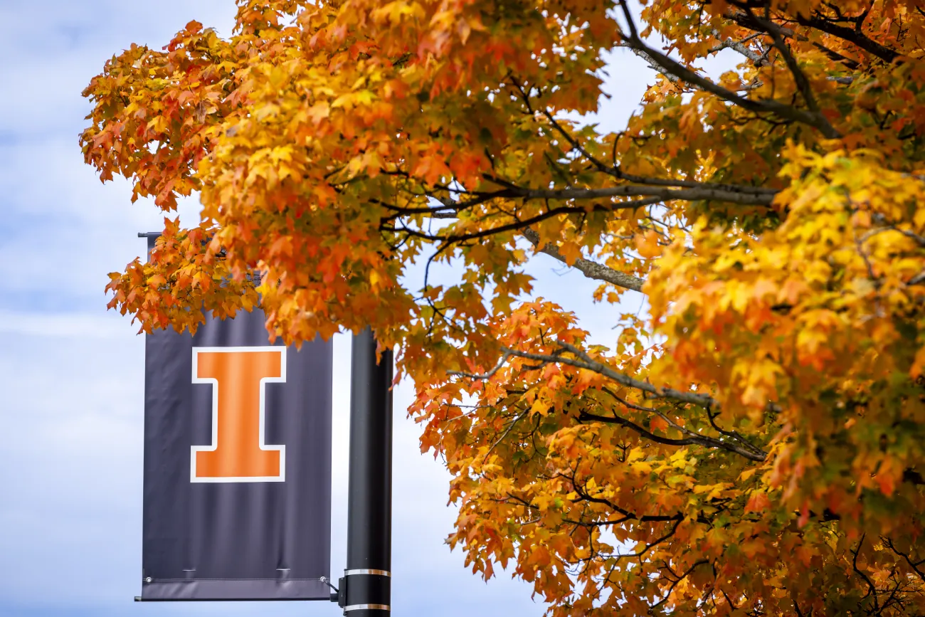 blue block-I street banner against bright orange fall foliage