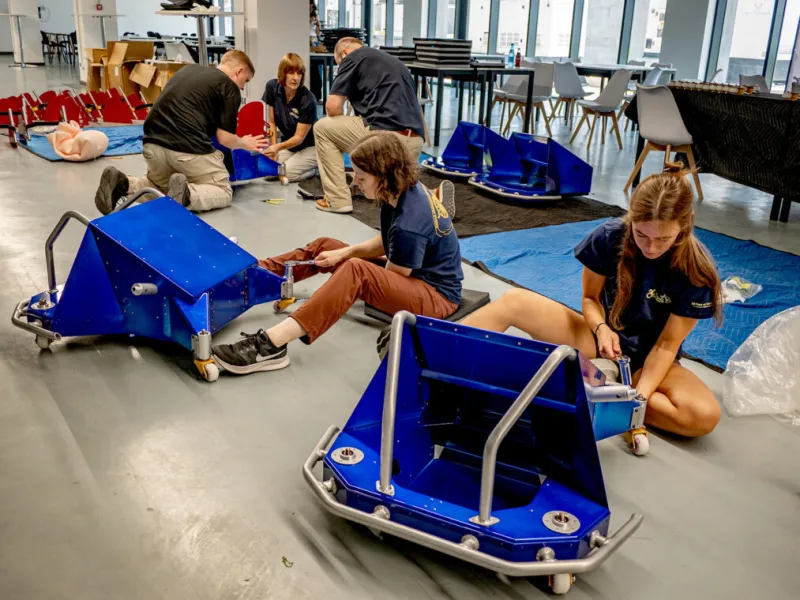 Team members assembling wheelchairs