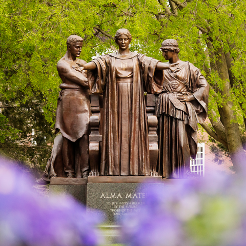 Alma Mater stands in front of a spring background.